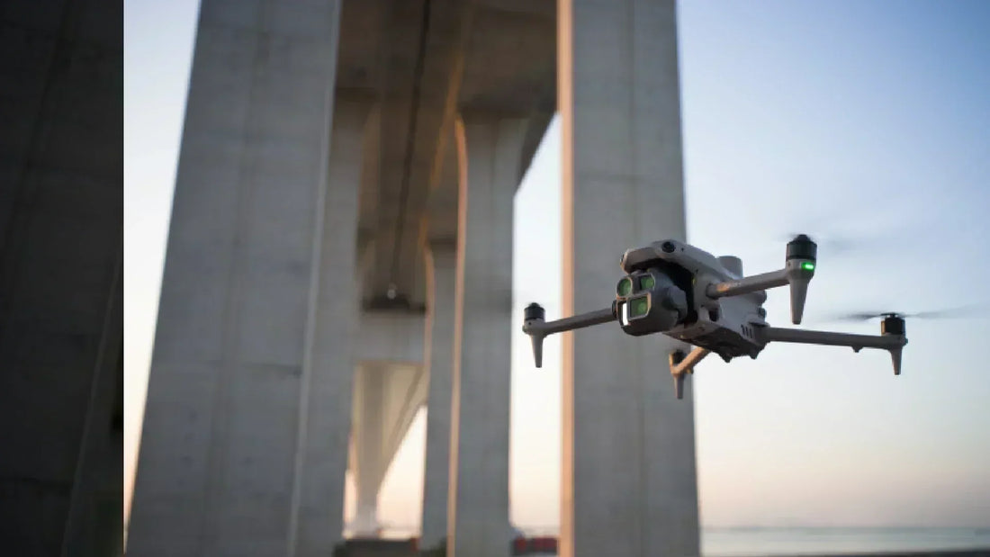 Drone performing bridge inspection with visible sensors during a wide-angle aerial shot, highlighting UAV use in infrastructure monitoring.