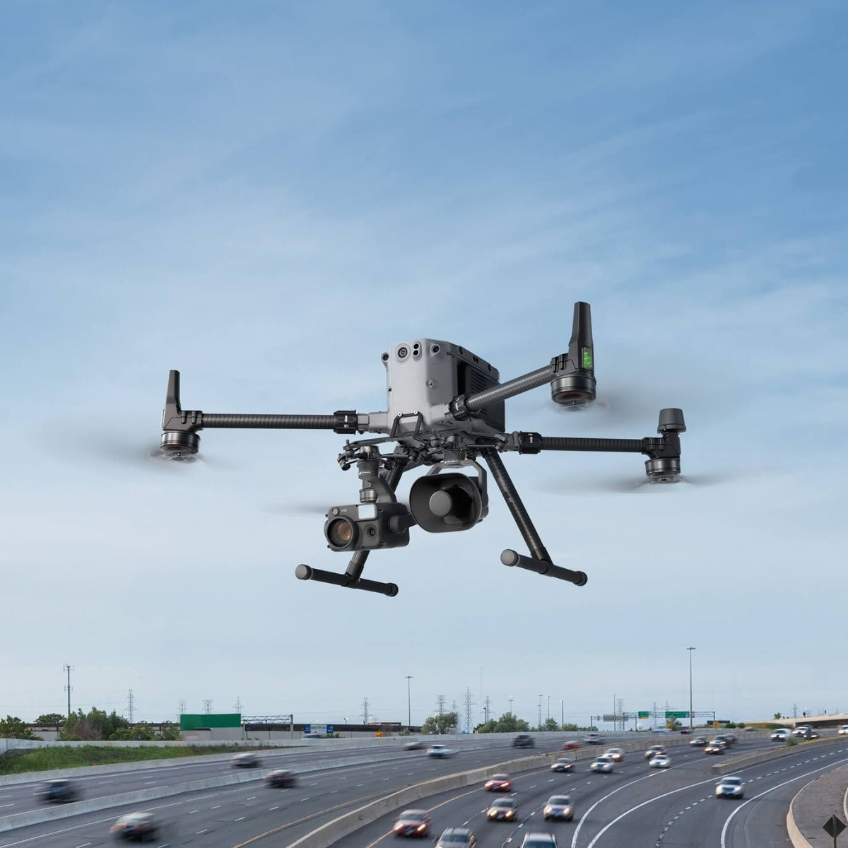 DJI Zenmuse V1 Speaker mounted under a Matrice 400 flying over a highway