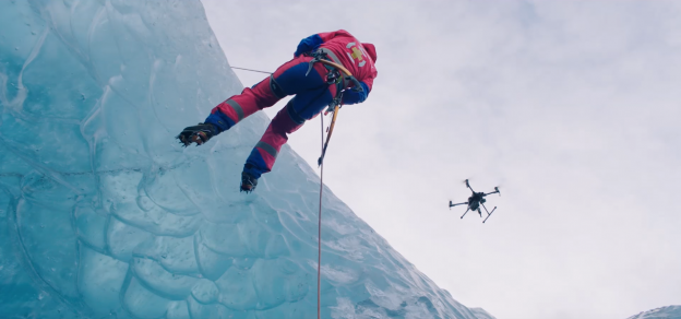 Search and rescue drone assisting a mountain rescue operation with a climber on an icy cliff, demonstrating DJI Zenmuse Z30 aerial imaging, thermal drone technology, emergency response, and public safety missions.