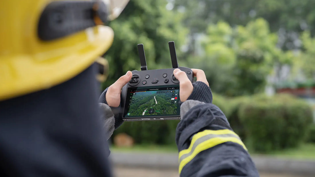 A person in firefighter gear operates a drone controller showing aerial footage of a forest. The scene conveys focus and advanced technology use.