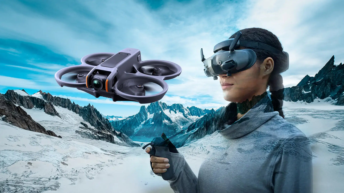 A person wearing VR goggles remotely pilots a drone over a snowy mountain landscape. The scene conveys a high-tech, adventurous tone.