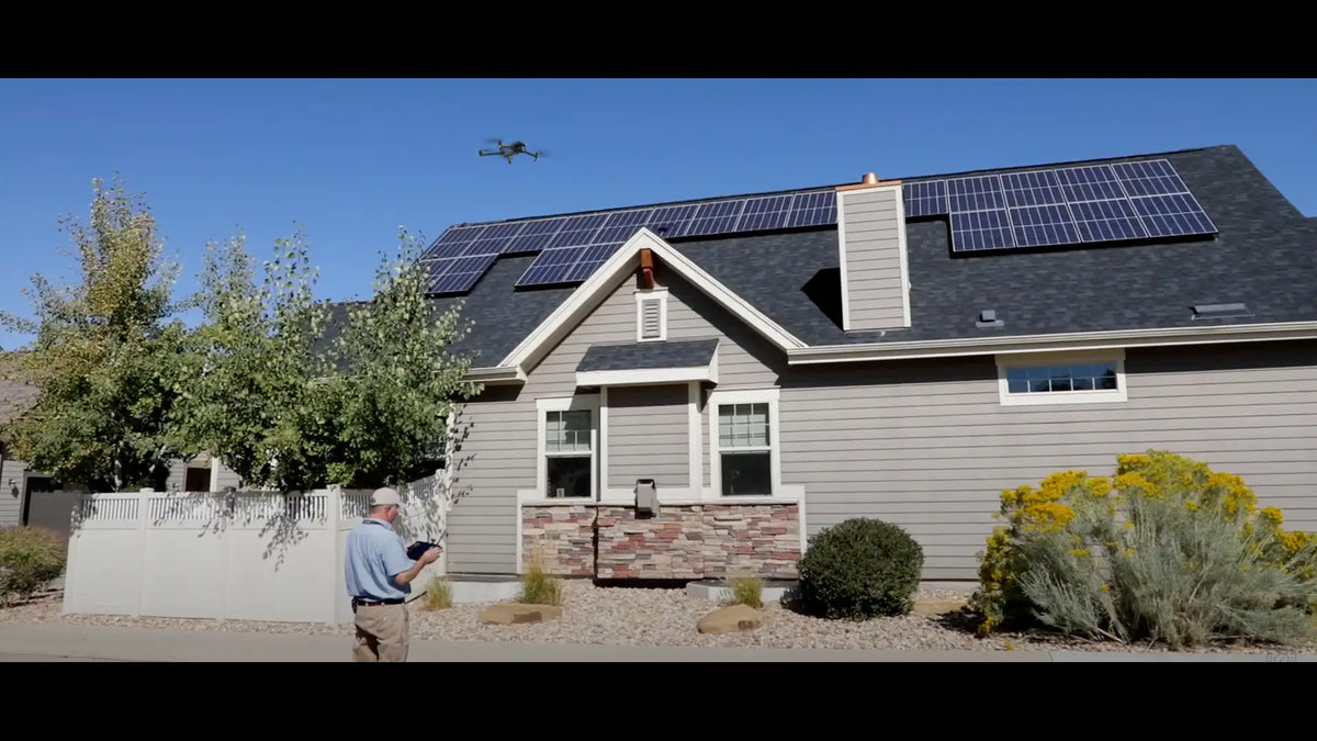 Drone performing a residential roof inspection with solar panels to assess roof conditions and identify maintenance issues.