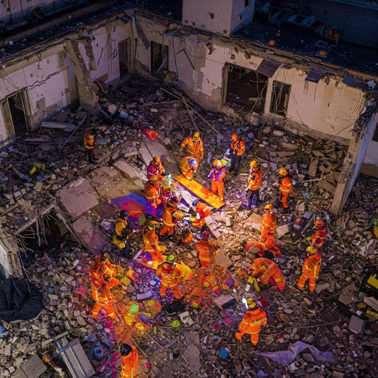Drone using thermal imaging to scan a collapsed building, helping search and rescue teams locate survivors while reducing responder risk.