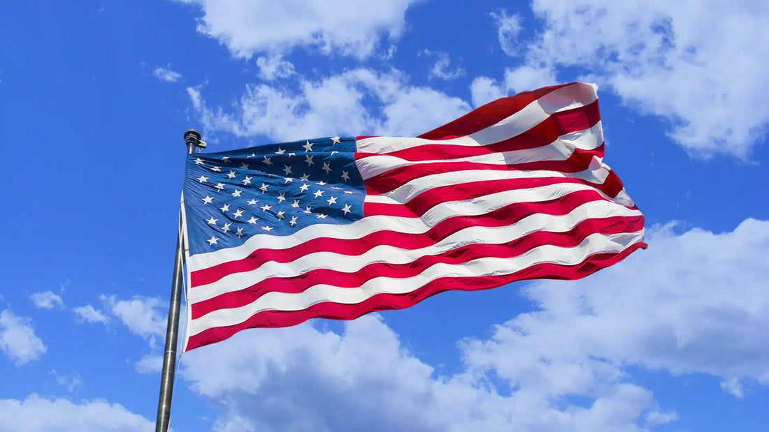 American flag waving against a blue sky, representing U.S. national security and proposed legislation restricting foreign-made drones under the STOP Illicit Drones Act.