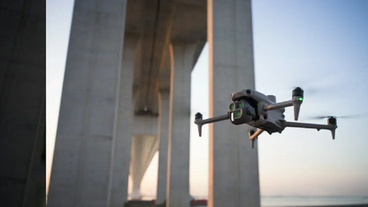 Drone performing bridge inspection with visible sensors during a wide-angle aerial shot, highlighting UAV use in infrastructure monitoring.