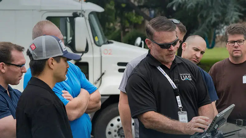 Public safety UAS instructor demonstrating a drone controller to a group