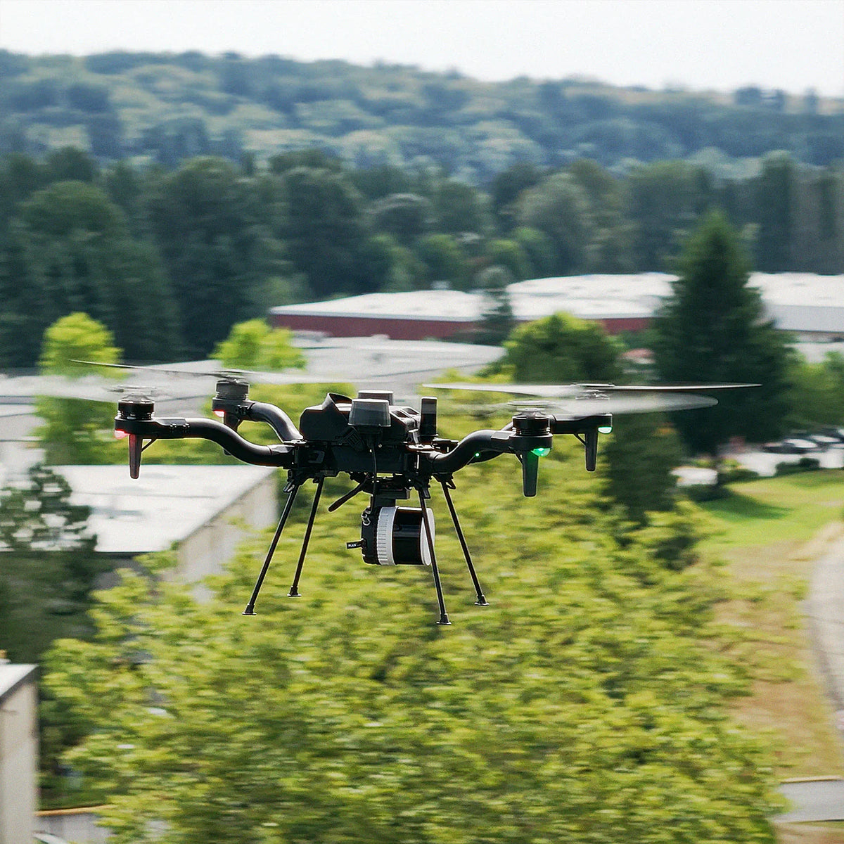 Freefly drone flying outdoors with a Flux H1 LiDAR payload mounted underneath