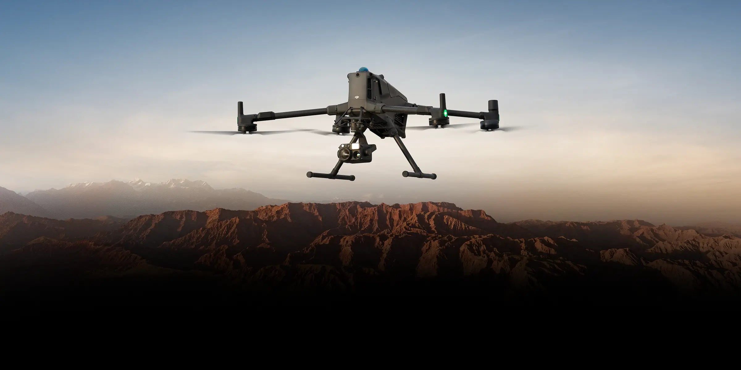 A Matrice 400 with a thermal payload flying over mountains.