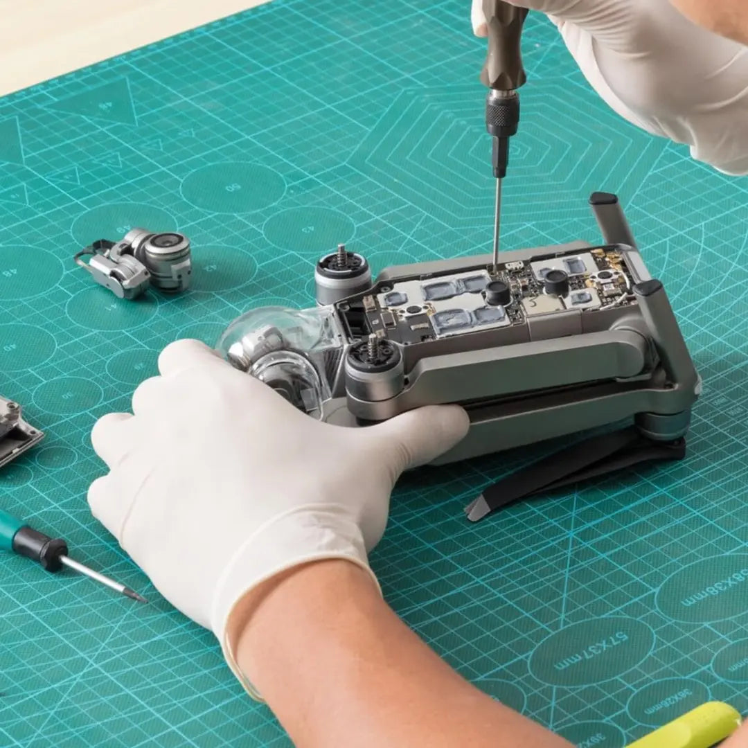 DSLRPros technician repairing drone with a screwdriver.